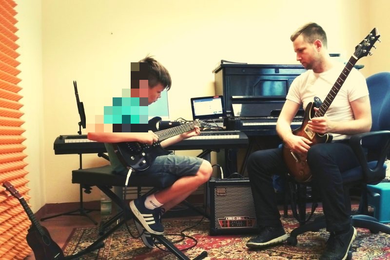 Uczeń z gitarą na zajęciach